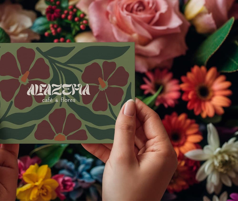 Mãos segurando cartão da Alfazema sobre mesa com flores